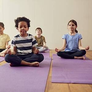 Kinder meditieren auf Yoga-Matten
