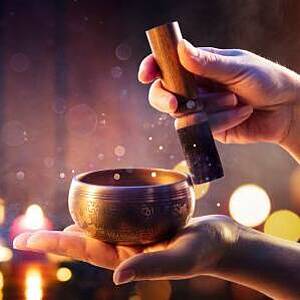 Jemand schlägt eine Klangschale an