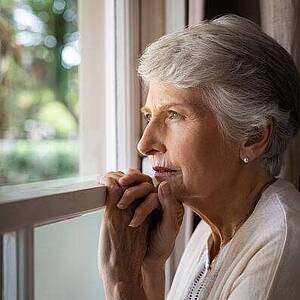 Seniorin blickt aus dem Fenster