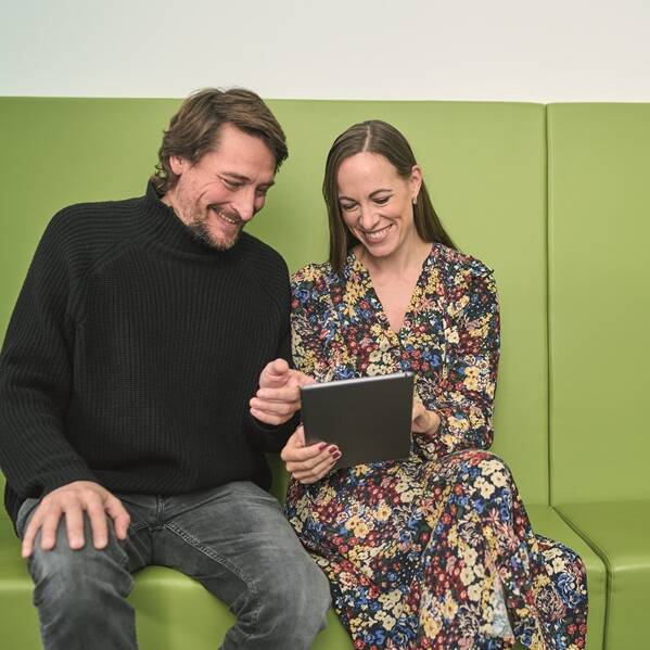 Ein Mann und eine Frauen blicken auf ein Tablet